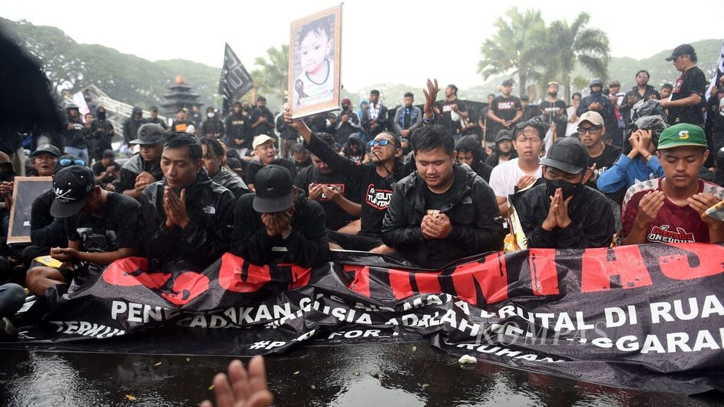 Aremania prays for the victims of the Kanjuruhan Tragedy during the "Malang Blackening" demonstration in Malang City Square, East Java, on Thursday (10/11/2022). 