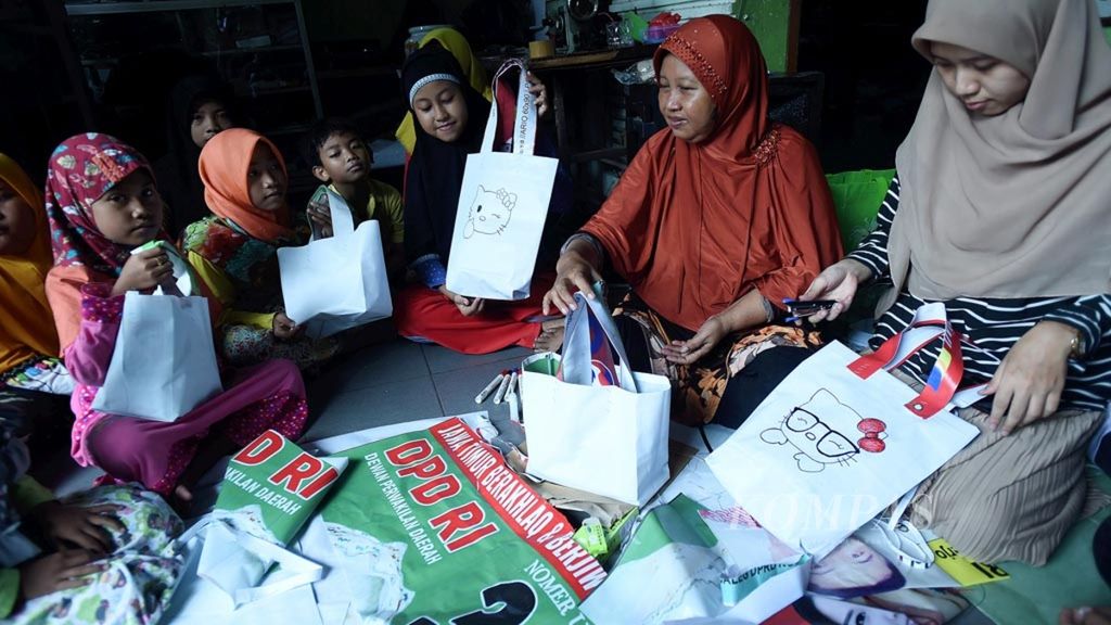 Anak-anak mengikuti pelatihan membuat tas berbahan dasar bekas alat peraga kampanye yang diselenggarakan Sekolah Rakyat Kejawan dan Komunitas Relawan Peduli Sekitar, di Surabaya, Jawa Timur, Minggu (14/4/2019).