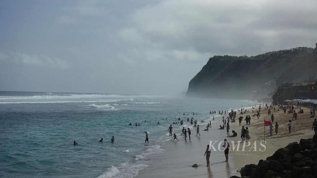 Wisatawan menikmati suasana Pantai Melasti di Ungasan, Kabupaten Badung, Bali, Minggu (3/7/2022).