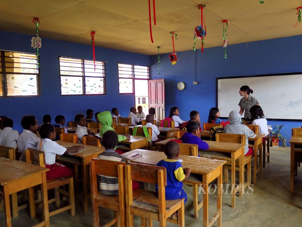 Peserta didik memperhatikan guru SM3T, Junisa Samosir, yang sedang mengajar di kelas tiga SD Inpres Tiom, Lanny Jaya, Papua, Selasa (28/7/2015). 