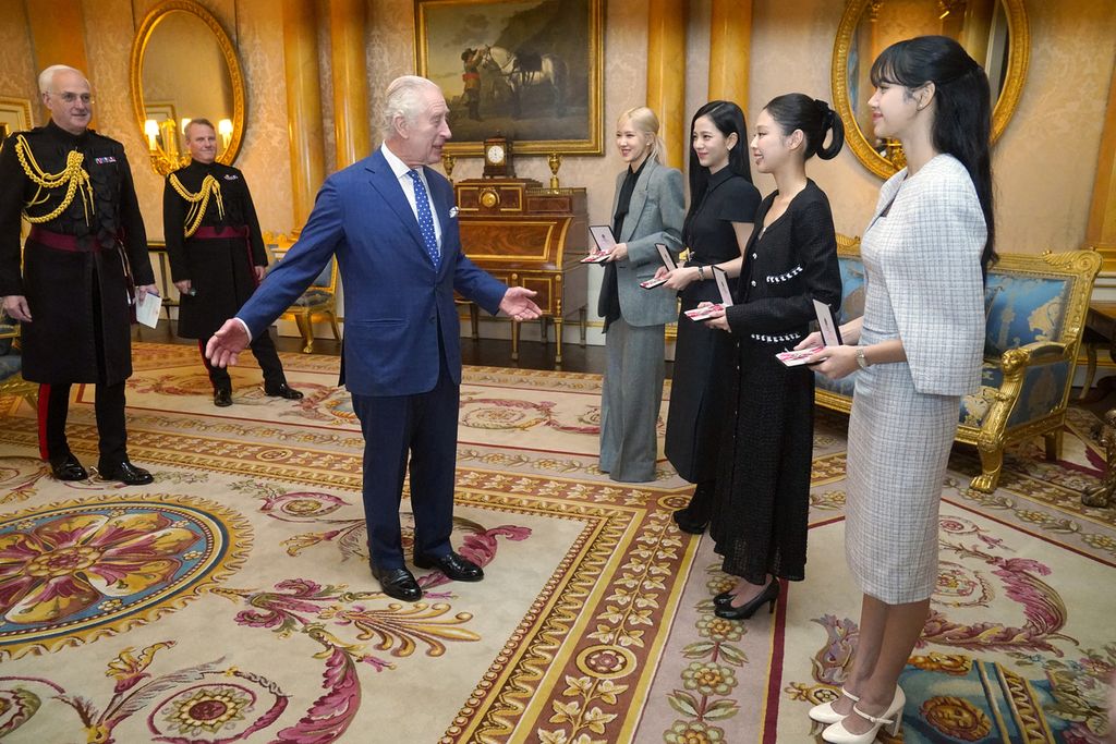 Raja Charles III menganugerahkan gelar kehormatan kepada Blackpink (empat di kanan), yaitu (dari kiri) Roseanne Park, Jisoo Kim, Jennie Kim, dan Lalisa Manoban, di Istana Buckingham, London, 22 November 2023.