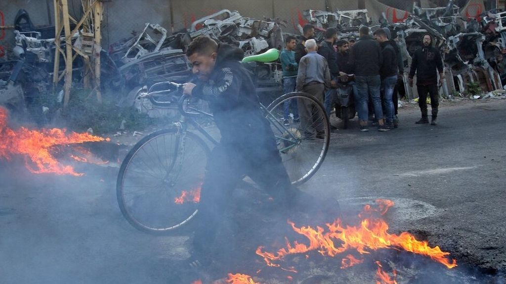 Seorang pengendara sepeda melintasi barikade yang didirikan oleh pengunjuk rasa di kota Sidon (Saida), Lebanon selatan, Rabu (3/3/2021). Pound Lebanon anjlok pada titik terendah akibat krisis ekonomi terburuk di negara itu sejak perang saudara pada 1975-1990. 