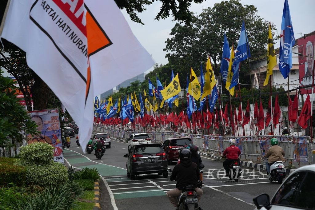 Pengendara melintasi bendera partai politik peserta Pemilu 2024 di HOS Cokroaminoto, Menteng, Jakarta Pusat, Kamis (4/1/2024).