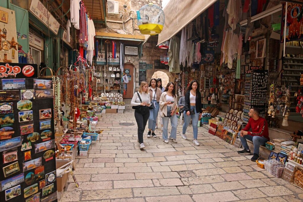 Wisatawan berjalan melewati toko-toko di Kota Tua Jerusalem pada 1 November 2021 setelah Israel membuka kembali bagi para turis yang telah divaksin Covid-19. 