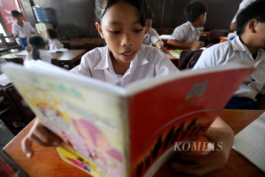 Murid membaca buku di Sekolah Darurat Kartini yang diasuh ibu guru kembar Sri Irianingsih dan Sri Rossyati di kawasan Ancol, Jakara Utara, Jumat (5/5/2023). 