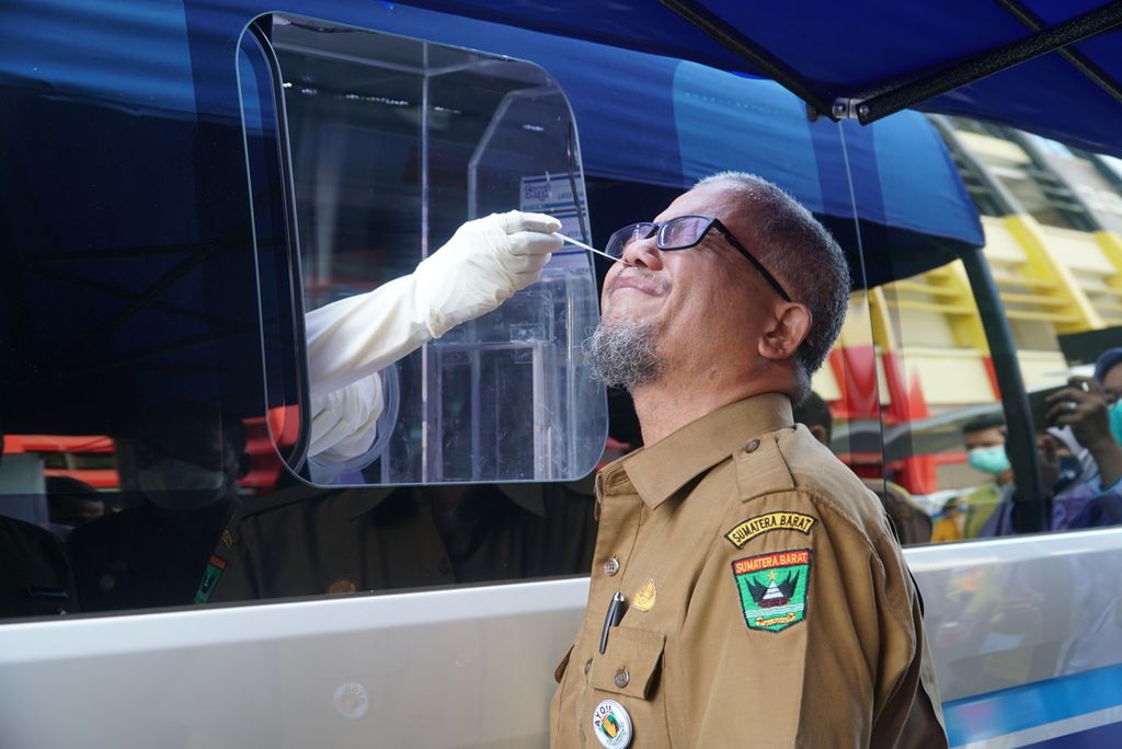 Petugas layanan mobil tes usap keliling mengambil sampel tes usap PCR seorang pegawai Pemerintah Provinsi Sumatera Barat di halaman Kantor Gubernur Sumbar, Padang, Sumbar, Senin (24/5/2021). Pemprov Sumbar meluncurkan layanan mobil tes usap PCR keliling untuk memperluas jangkauan tes Covid-19 di kabupaten/kota di Sumbar dalam menekan penularan kasus Covid-19.