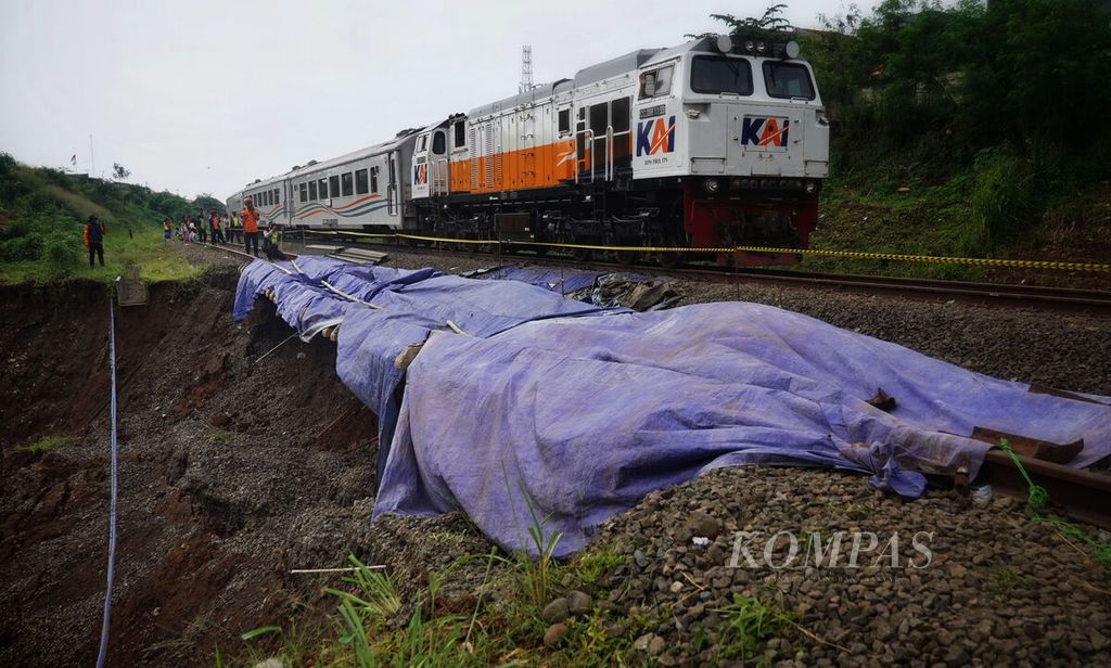 Kereta api Bogor-Sukabumi yang beroperasi dan melintas di lajur rel kereta yang tidak terdampak longsoran di Kampung Sirna Sari, Kelurahan Empang, Kota Bogor, Jawa Barat, Kamis (16/3/2023). 
