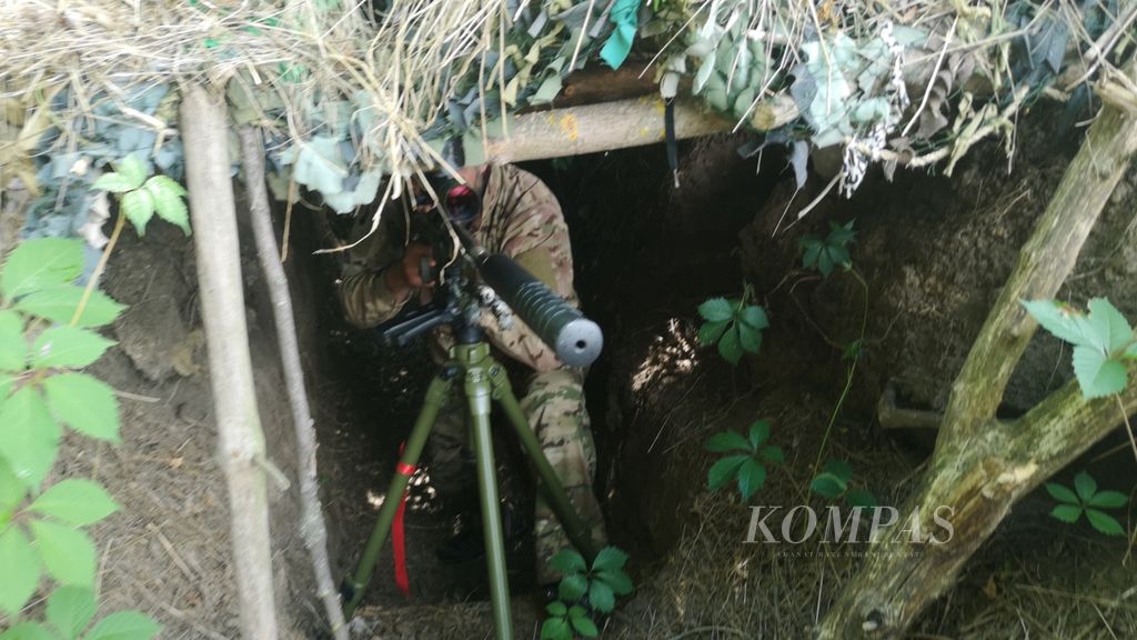 Seorang milisi bersiaga di sebuah parit pertahanan di daerah Ukraina bagian selatan, Kamis (23/6/2022). Parit ini digunakan sebagai wilayah pertahanan milisi Ukraina saat ada serangan Rusia.