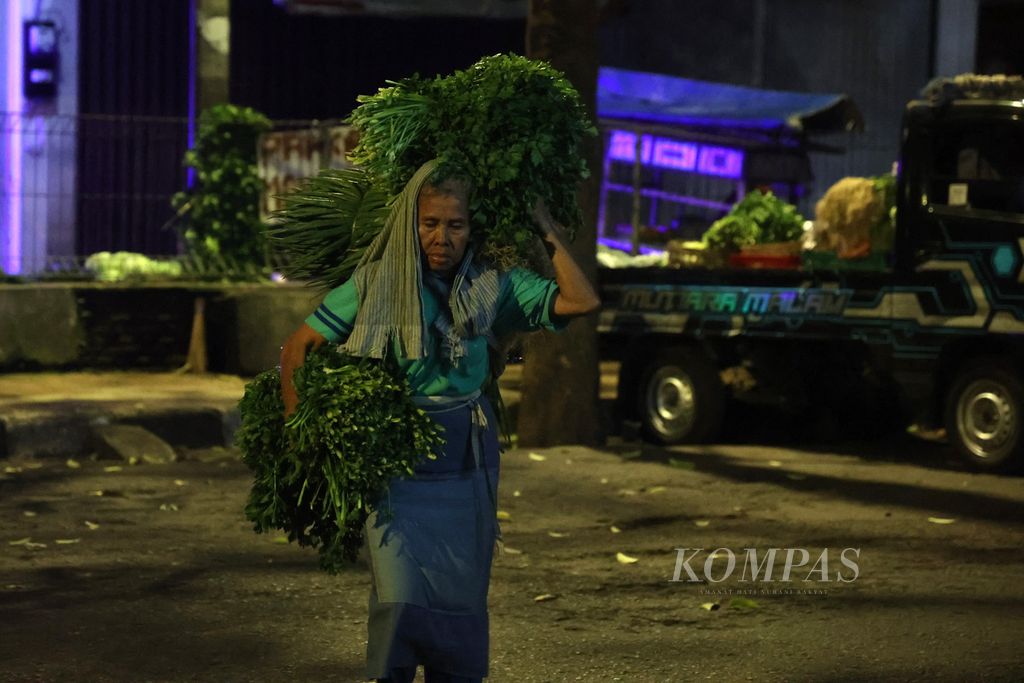 Buruh gendong bernama Pariyem (67) bekerja memindahkan barang milik pedagang di Pasar Beringharjo, Yogyakarta, Selasa (7/3/2023) dini hari. Saat ini terdapat 210 perempuan buruh gendong di Pasar Beringharjo.