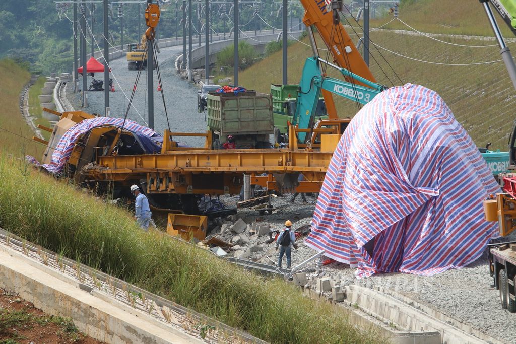 Sejumlah petugas memantau evakuasi kereta kerja dari proyek Kereta Cepat Jakarta–Bandung yang mengalami kecelakaan di Desa Cempakamekar, Kecamatan Padalarang, Kabupaten Bandung Barat, Jawa Barat, Senin (19/12/2022).
