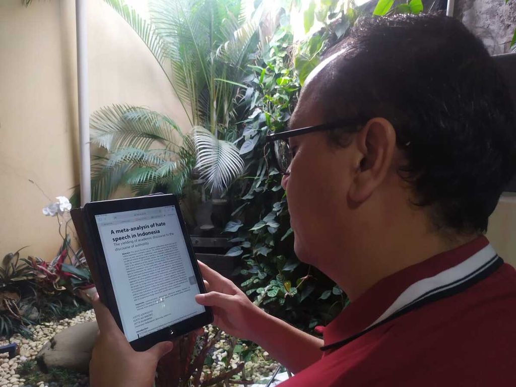 Dosen Metode Kuantitatif Fakultas Ilmu Komunikasi Universitas Padjadjaran, S Kunto Wibowo, membaca tulisan yang dimuat di jurnal lewat gawainya di Bandung, Jawa Barat, Jumat (11/2/2022).