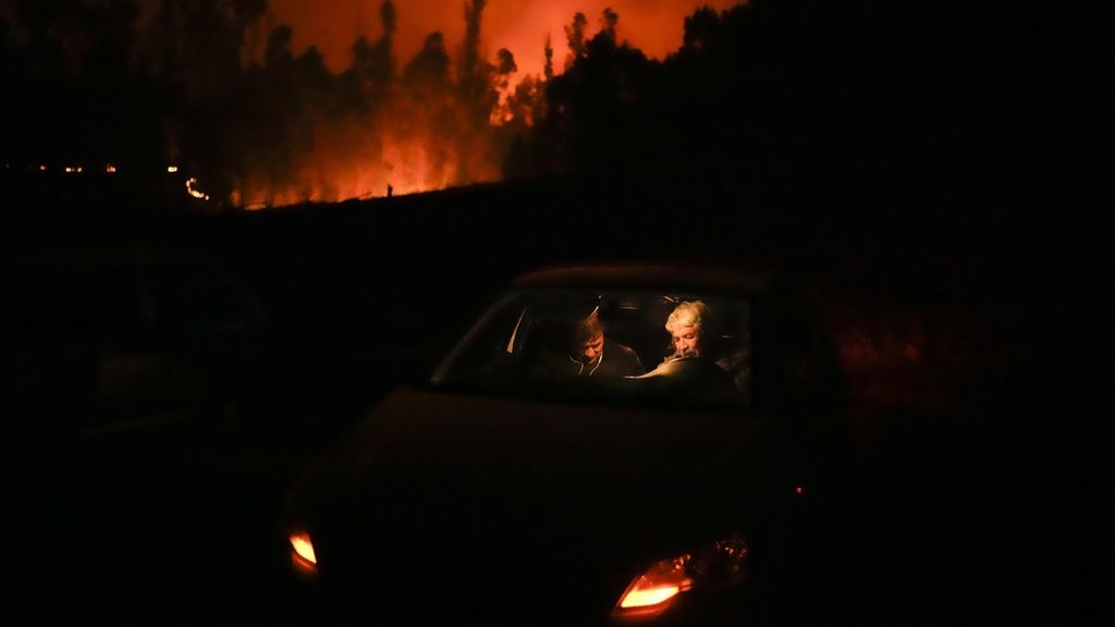 Warga berlindung di dalam mobil di dekat hutan yang terbakar di Puren, Chile, Sabtu (4/2/2023) malam waktu setempat. Kebakaran hutan menyebar di Chile selatan dan tengah, memicu evakuasi dan pernyataan keadaan darurat di beberapa daerah. 
