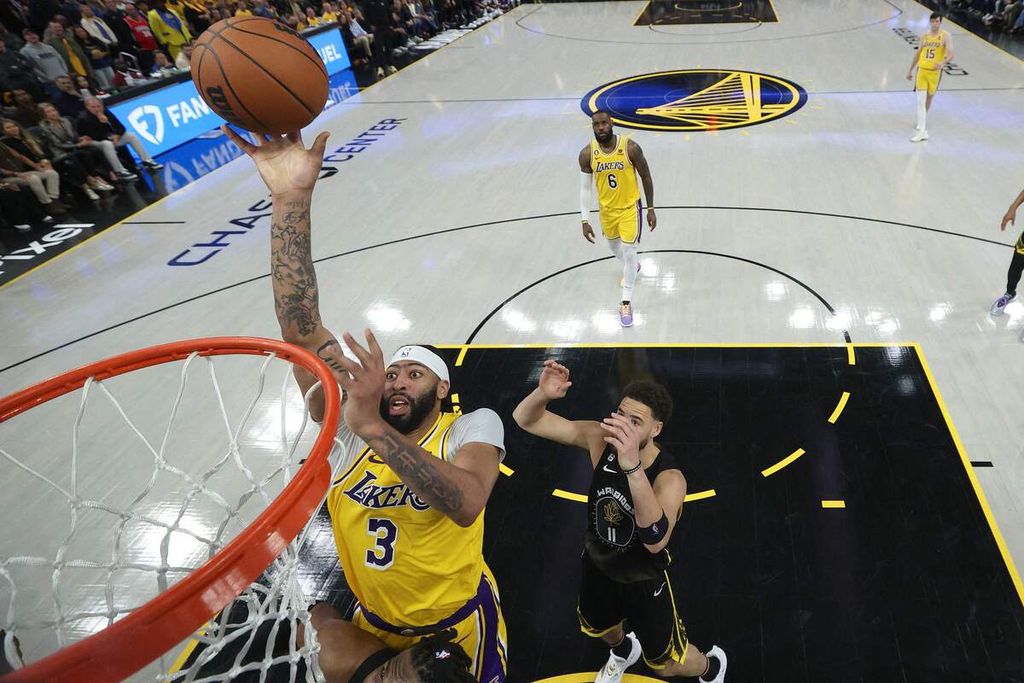 Pemain Los Angeles Lakers, Anthony Davis, coba memasukkan bola melewati pemain Golden State Warriors, Klay Thompson, saat pertandingan pertama babak semifinal Wilayah Barat <i>playoff</i> NBA antara Warriors dan LA Lakers di Chase Center, San Francisco, Rabu (3/5/2023) WIB. Lakers mengalahkan tuan rumah, 117-112. 