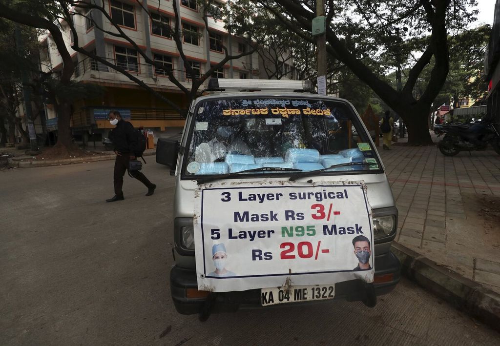 Penjual masker berkeliling untuk menawarkan masker di Bengaluru, ibu kota negara bagian Karnataka, India, Kamis (2/12/2021). India pada Kamis mengonfirmasi kasus pertama Covid-19 galur Omicron pada dua pria di Karnataka yang tiba dari luar negeri. 