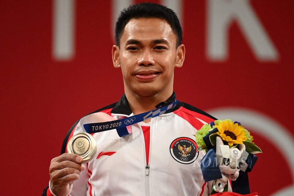Eko Yuli Irawan, peraih medali perak angkat besi 61 kilogram putra Olimpiade Tokyo 2020, saat berada di podium dalam upacara penganugerahan medali, di Tokyo International Forum, Minggu (25/7/2021).