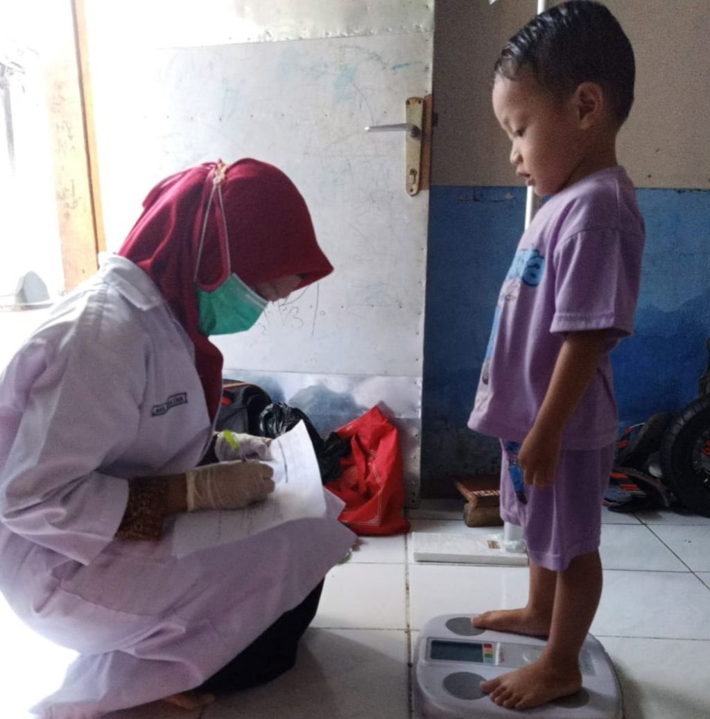 Kader posyandu mencatat berat tubuh anak balita saat kunjungan ke rumah warga di Surabaya, Jawa Timur, Jumat (21/8/2020). Pertumbuhan anak balita dipantau untuk mengantisipasi anak <i>stunting</i> atau gagal tumbuh akibat kurang gizi.