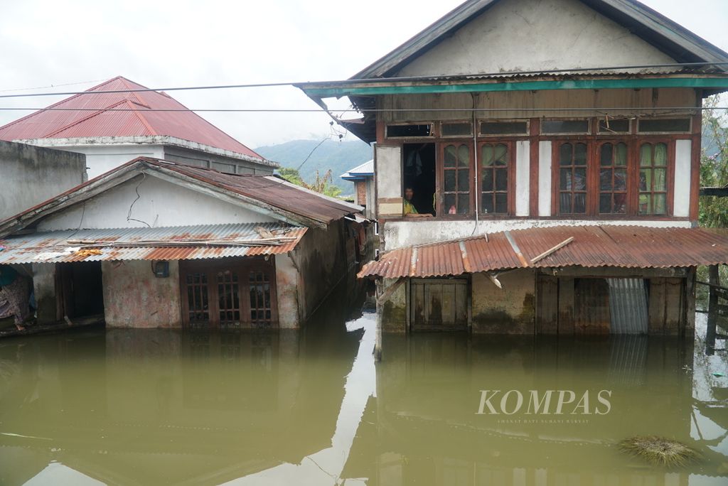 Warga duduk di lantai 2 rumahnya karena lantai dasar terendam banjir akibat meluapnya Batang Merao di Desa Tanjung, Kecamatan Hamparan Rawang, Kota Sungai Penuh, Jambi, Sabtu (20/1/2024). 