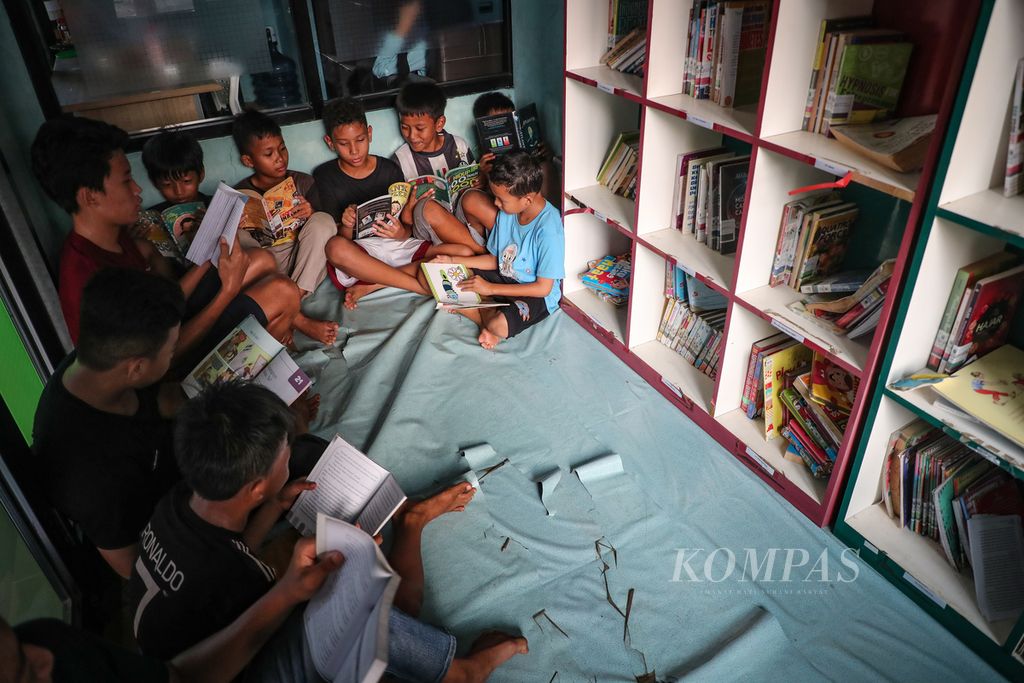 Anak-anak membaca buku di RPTRA Asoka, Jakarta Selatan, Rabu (4/10/2023). RPTRA ini menyediakan taman bermain, lapangan futsal, dan perpustakaan. 