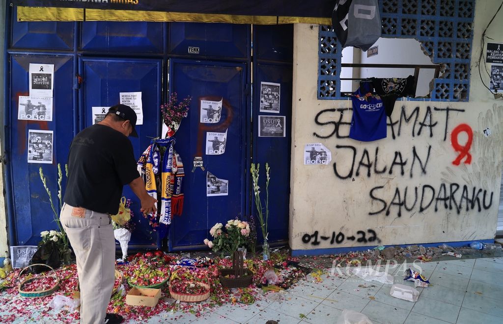Warga menabur bunga di depan pintu yang menjadi saksi bisu Tragedi Kanjuruhan yang menewaskan 131 orang seusai laga Arema FC melawan Persebaya di Stadion Kanjuruhan, Kepanjen, Malang, Jawa Timur, Selasa (4/10/2022).