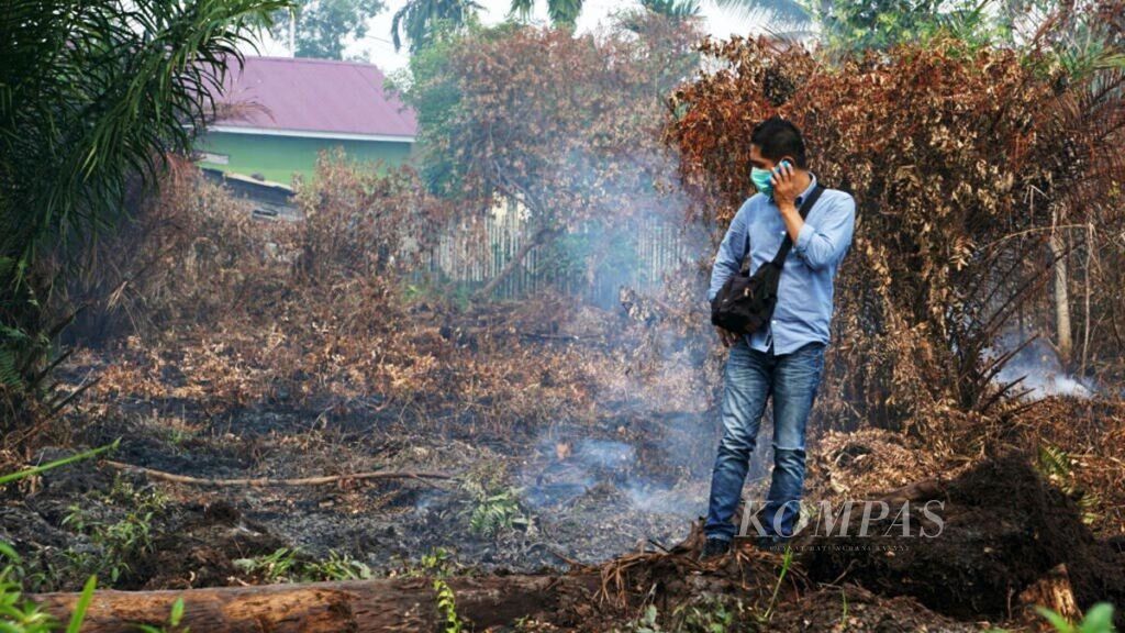 Petugas melakukan penyiraman di lokasi lahan gambut yang terbakar di Jalan Meranti Darat, Kelurahan Simpang Tetap Darul Ichsan, Kecamatan Dumai Barat, Kota Dumai, Provinsi Riau, Jumat (22/2/2019). 