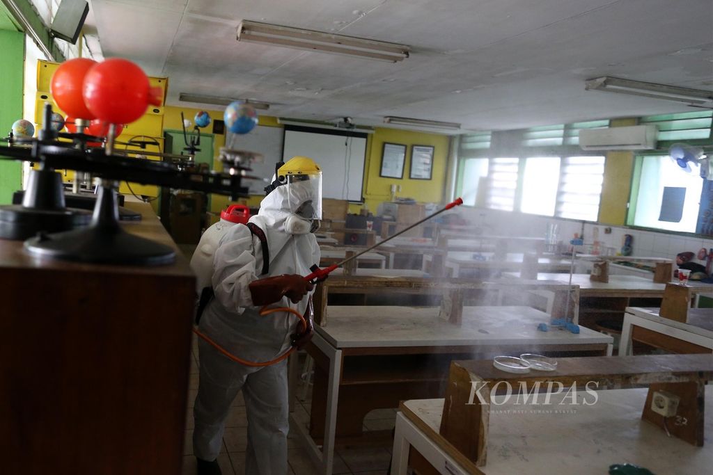Petugas PMI Jakarta Pusat menyemprot ruang laboratorium SMP 216, Kenari, Senen, Jakarta Pusat, dengan cairan disinfektan, Senin (22/6/2020).