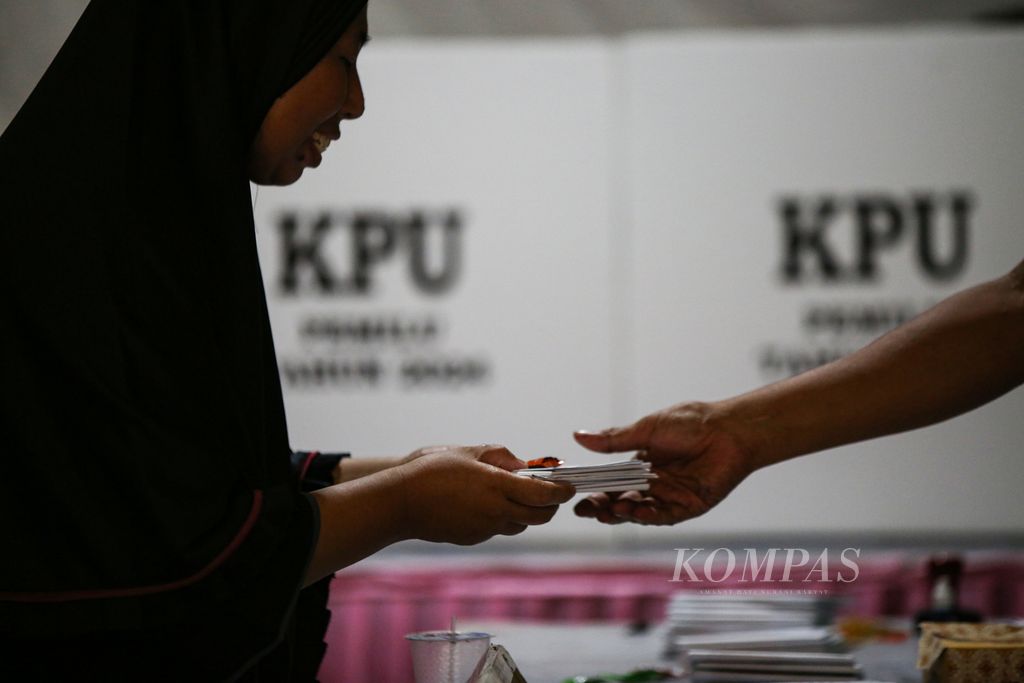 Warga menerima surat suara dari petugas Kelompok Penyelenggara Pemungutan Suara (KPPS) dalam pemungutan suara susulan Pemilu 2024 di Tempat Pemungutan Suara  06 di RT 003 RW 001, Larangan Utara, Larangan, Kota Tangerang, Banten, Minggu (18/2/2024). 