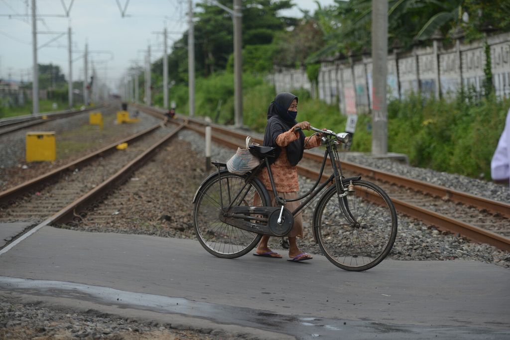 Pengguna sepeda melintas di pelintasan sebidang sebelah barat Stasiun Klaten, Kabupaten Klaten, Jawa Tengah, Jumat (4/12/2020). 