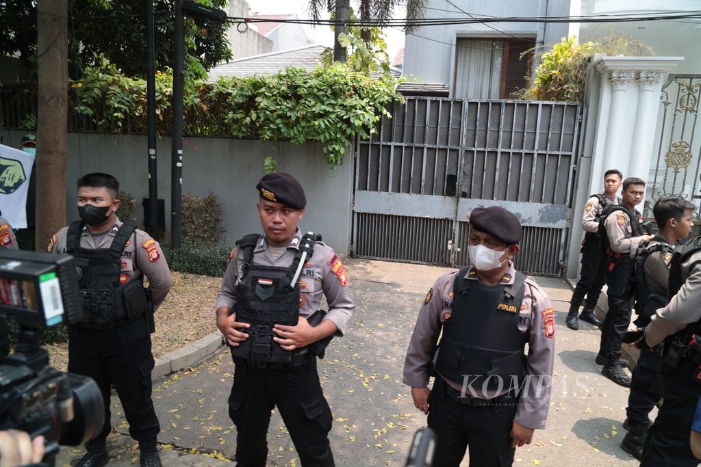Anggota kepolisian berjaga di depan rumah aman (<i>safe house</i>) Ketua Komisi Pemberantasan Korupsi Firli Bahuri yang tengah digeledah penyidik Direktorat Reserse Kriminal Khusus Polda Metro Jaya di kawasan Kebayoran Baru, Jakarta, Kamis (26/10/2023). 