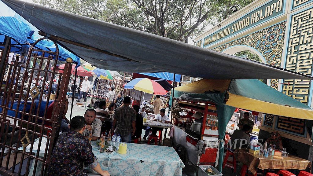 Warga  menikmati kuliner  di luar pagar Masjid Sunda Kelapa, Menteng, Jakarta Pusat, Jumat (26/5). Pusat kuliner menu Nusantara itu mulai dibuka sejak tahun 1970-an, yang hingga kini menjadi persinggahan hingga para pejabat negara.