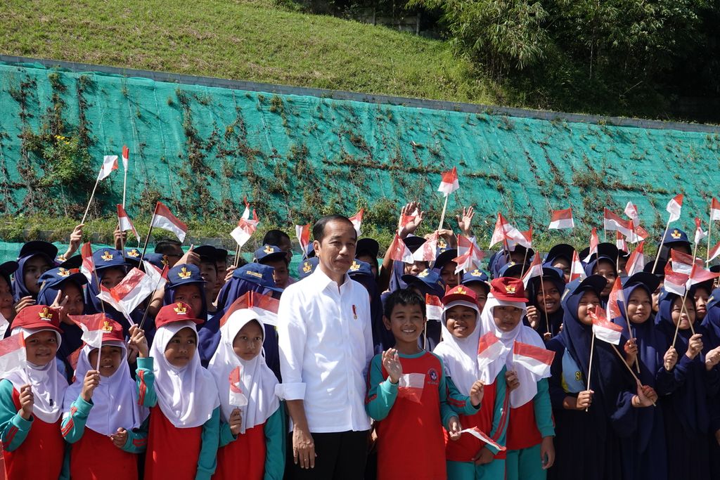 Presiden Joko Widodo berfoto dengan murid sekolah  seusai meresmikan Jalan Tol Cileunyi-Sumedang-Dawuan (Cisumdawu) di depan terowongan <i>twin tunnel</i>, Tol Cisumdawu KM 169, Kabupaten Sumedang, Jawa Barat, pada Selasa (11/7/2023). 