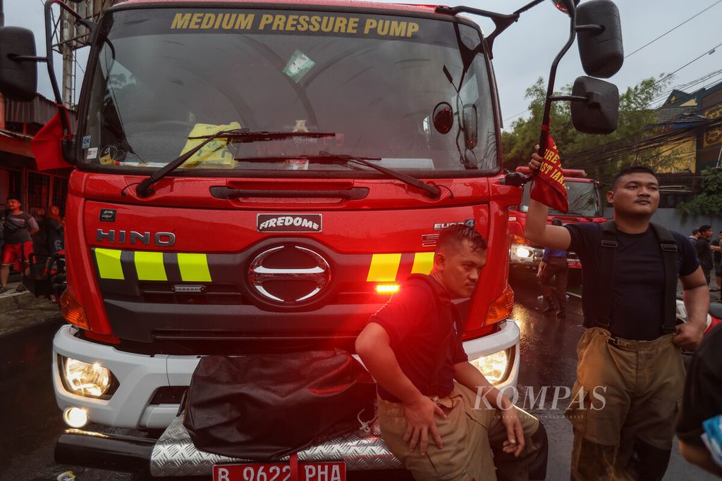 Dua petugas pemadam kebakaran beristirahat di tengah proses pendinginan di Jalan Dr Saharjo, Kecamatan Setiabudi, Jakarta Selatan, Kamis (11/1/2024).