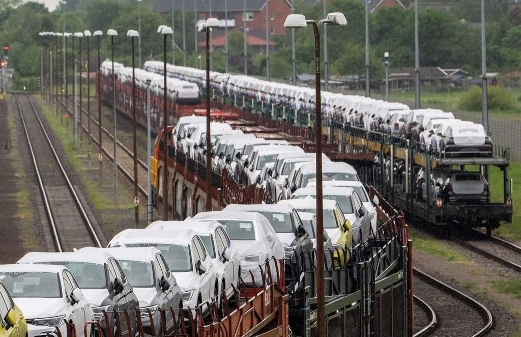 Foto yang diambil pada 20 Mei 2022 ini memperlihatkan mobil-mobil buatan Volkswagen (VW) diangkut dengan kereta di kompleks pabriknya di Emden, wilayah utara Jerman. 