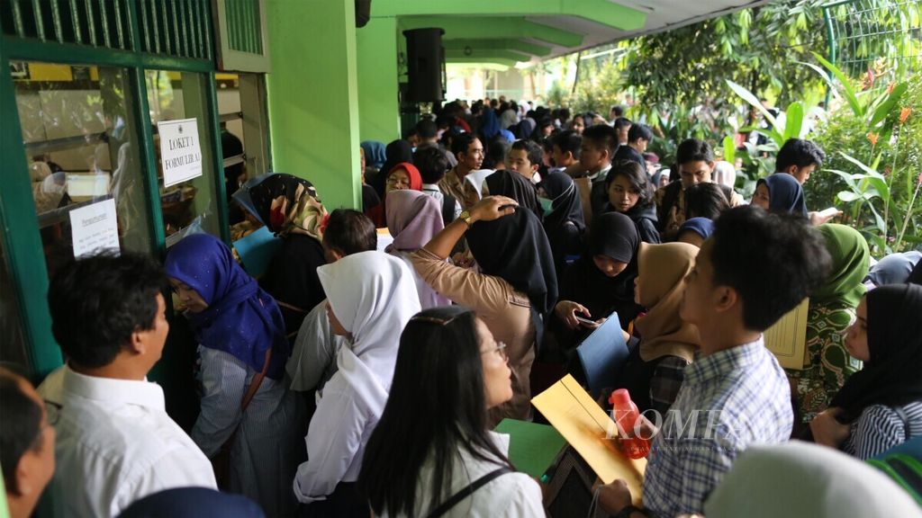 Orangtua dan calon siswa antre untuk mendaftar saat penerimaan peserta didik baru SMA Negeri 47 Jakarta Selatan di kawasan Kebayoran Lama, 24 Juni 2019. 