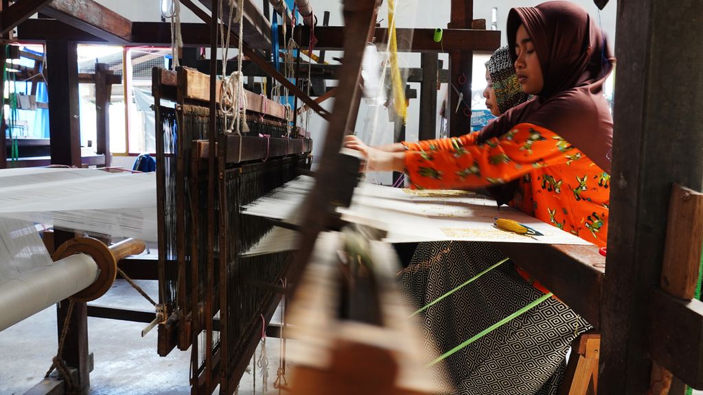 Pekerja menyelesaikan pengerjaan kain tenun Siak di tempat pembuatan tenun Mekar Permai di Jalan Indragiri, Kota Siak Sri Inderapura, Kabupaten Siak, Riau, Jumat (27/12/2019). 