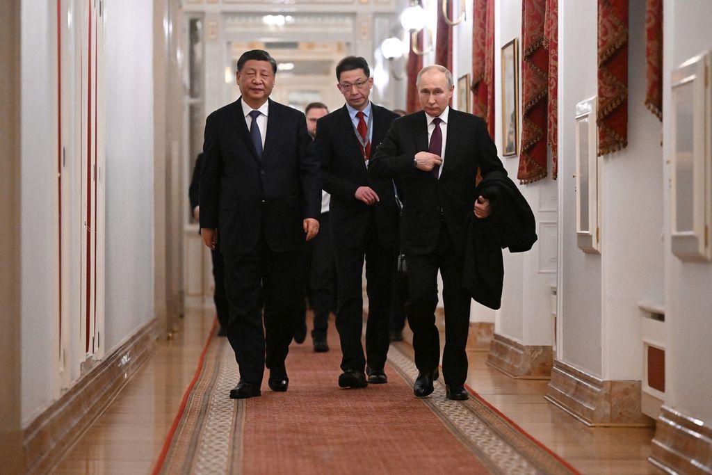 Presiden China Xi Jinping (kiri) dan Presiden Rusia Vladimir Putin berjalan setelah menggelar pembicaraan di Kremlin di Moskwa, Rusia, Senin (20/3/2023). (Grigory Sysoyev, Sputnik, Kremlin Pool Photo via AP)