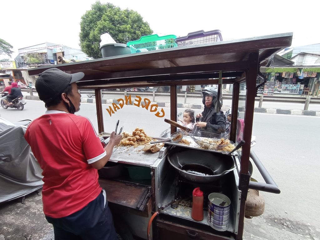 Soleh (42) melayani pembeli gorengannya di Pasar Lembang, Kecamatan Ciledug, Kota Tangerang, Banten, Senin (21/2/2022).