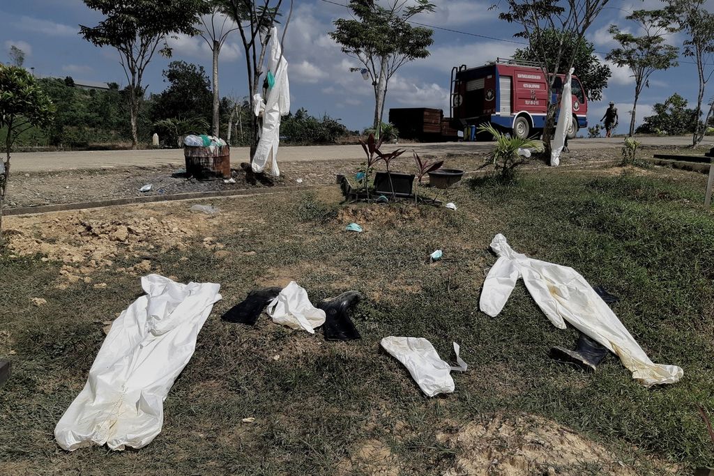 Alat pelindung diri yang dipakai petugas pemakaman dijemur di antara makam pasien Covid-19 di Gedung Krematorium Kompleks Pemakaman Km 15 Balikpapan, Kalimantan Timur, Senin (19/7/2021).