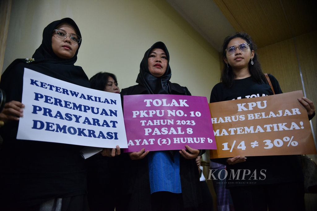 Peserta aksi membawa poster penolakan Peraturan Komisi Pemilihan Umum (PKPU) Nomor 10 Pasal 8 saat sesi konferensi pers di kompleks Badan Pengawas Pemilu (Bawaslu), Jakarta Pusat, Senin (8/4/2023). 