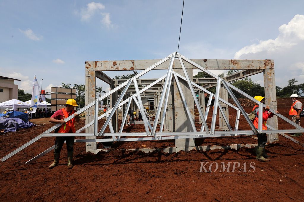 Pekerja memindahkan konstruksi kuda-kuda atap dari baja ringan saat pembangunan konstruksi modul rumah tahan gempa dengan teknologi panel struktur RISHA (Rumah instan Sederhana Sehat) di Desa Sirnagalih, Kecamatan Cilaku, Kabupaten Cianjur, Jawa Barat, Senin (5/12/2022). 