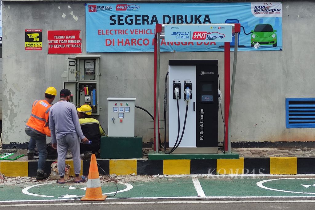 Pekerja menyelesaikan pemasangan stasiun pengisian kendaraan listrik umum (SPKLU) PLN di halaman parkir Harco Mangga Dua, Jakarta, Sabtu (29/3/2024). PLN berencana menambah jumlah dan lokasi persebaran SPKLU sepanjang 2024.  
