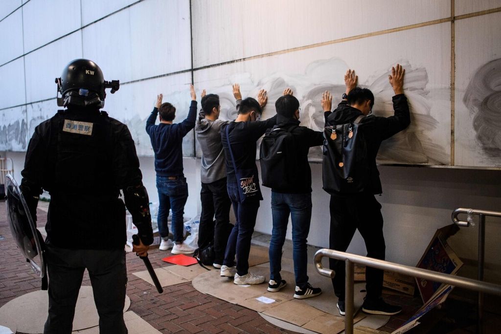 Dalam arsip foto yang diambil pada 22 Desember 2019 ini, orang-orang ditahan oleh polisi setelah rapat umum di Hong Kong untuk menunjukkan dukungan bagi minoritas Uighur di Tiongkok. 