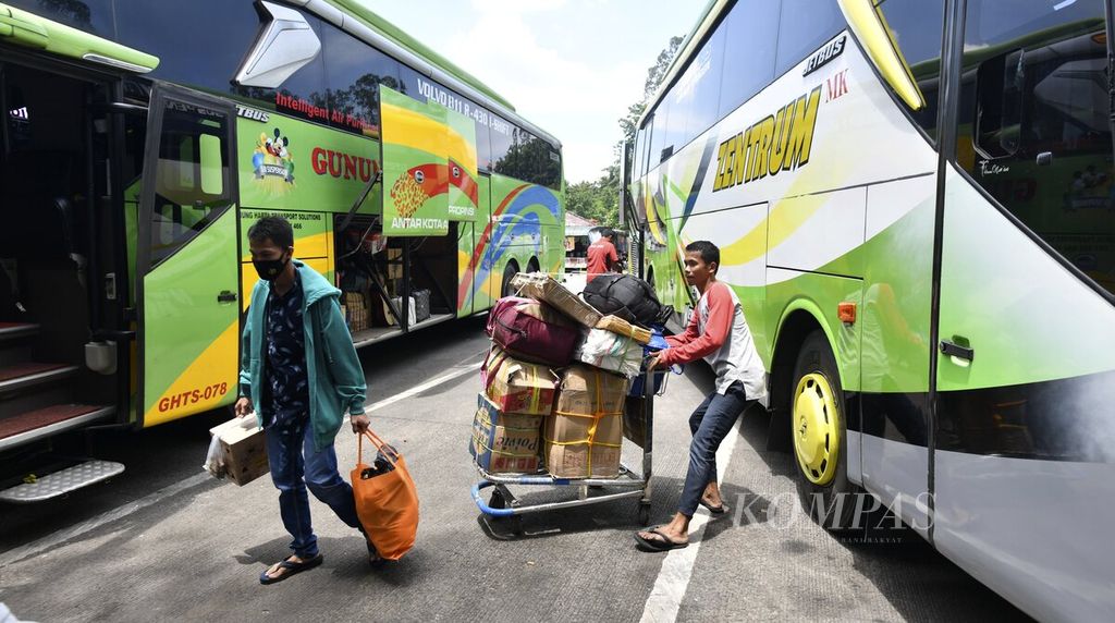 Awak bus menggunakan troli saat membawa barang-barang penumpang bus antarkota antarprovinsi yang akan dimasukkan ke dalam bagasi bus di Terminal Poris Plawad, Kota Tangerang, Banten, Sabtu (9/4/2022). 