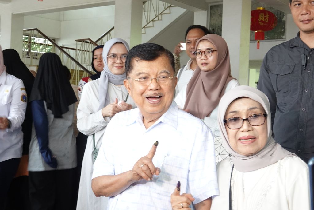 Wakil Presiden ke-10 dan ke-12 RI Jusuf Kalla beserta Nyonya Mufidah menunjukkan jari dengan tinta ungu tanda telah mencoblos di TPS 03 Kelurahan Pulo, Kebayoran Baru, Jakarta Selatan, Rabu (14/2/2024). 