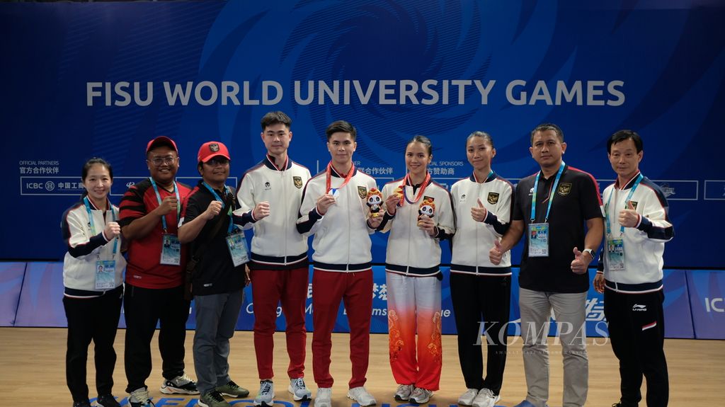 Pelatih wushu dan ofisial berfoto dengan Edgar Xavier Marvelo (kelima dari kanan) dan Nandhira Mauriskha (keempat dari kanan) yang meraih medali di ajang Universiade Chengdu, China, Sabtu (29/7/2023).