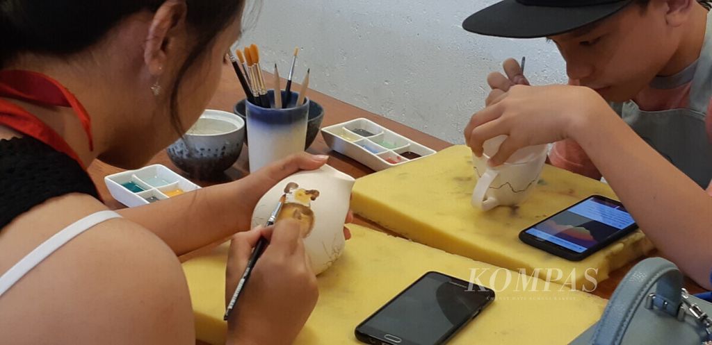 Dua remaja tengah berkreasi melukis dikeramik, di Galeri Jenggala, Bali, Selasa (19/3/2019). Kreativitas, inovasi dan jiwa kegigihan perlu dipupuk sebelum mereka lulus SMA/SMK agar jiwa wirausaha berkembang.