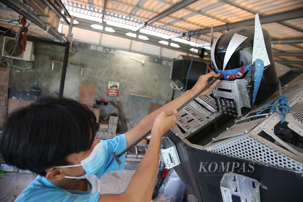 Andri menyelesaikan pembuatan robot berbahan limbah komputer di Kampong Robot, Jombang, Tangerang Selatan, Banten, Sabtu (23/4/2022).
