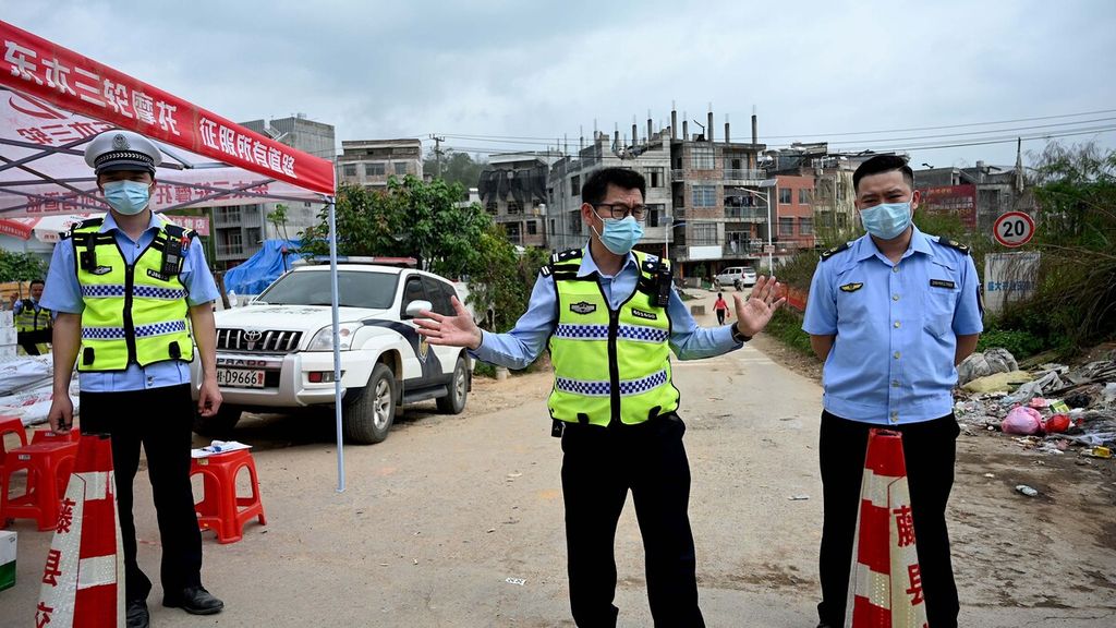 Polisi berjaga di pos pemeriksaan desa Langnan, di Wuzhou, tak jauh dari tempat jatuhnya pesawat China Eastern MU5375, Selasa (22/3/2022).  