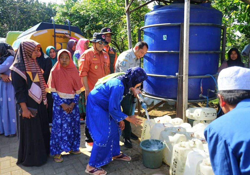 Badan Penanggulangan Bencana Daerah Jawa Timur menyalurkan bantuan air bersih di Desa Kunjorowesi, Kabupaten Mojokerto, Selasa (6/8/2024). Krisis air bersih melanda daerah ini sebulan terakhir. 