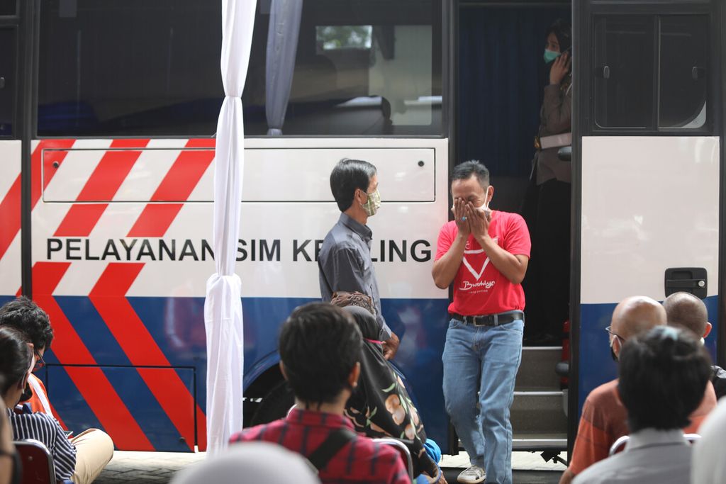 Warga menunjukkan gestur tanda bersyukur setelah urusannya selesai saat memperpanjang SIM di kantor pelayanan Samsat Jakarta Timur, Rabu (3/6/2020). 