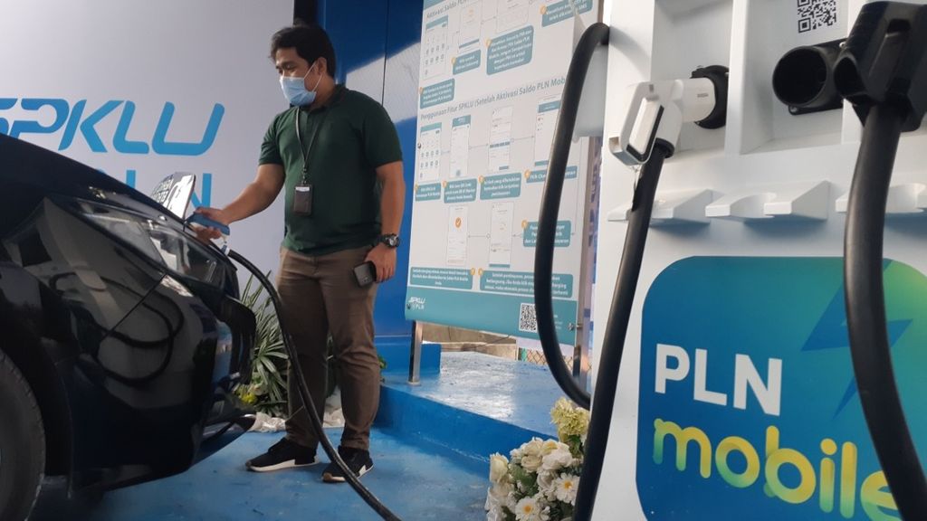 Seorang petugas sedang mengisi bahan bakar listrik ke salah satu mobil listrik di stasiun pengisian kendaraan listrik umum di Palembang, Sumsel, Selasa (18/1/2022).